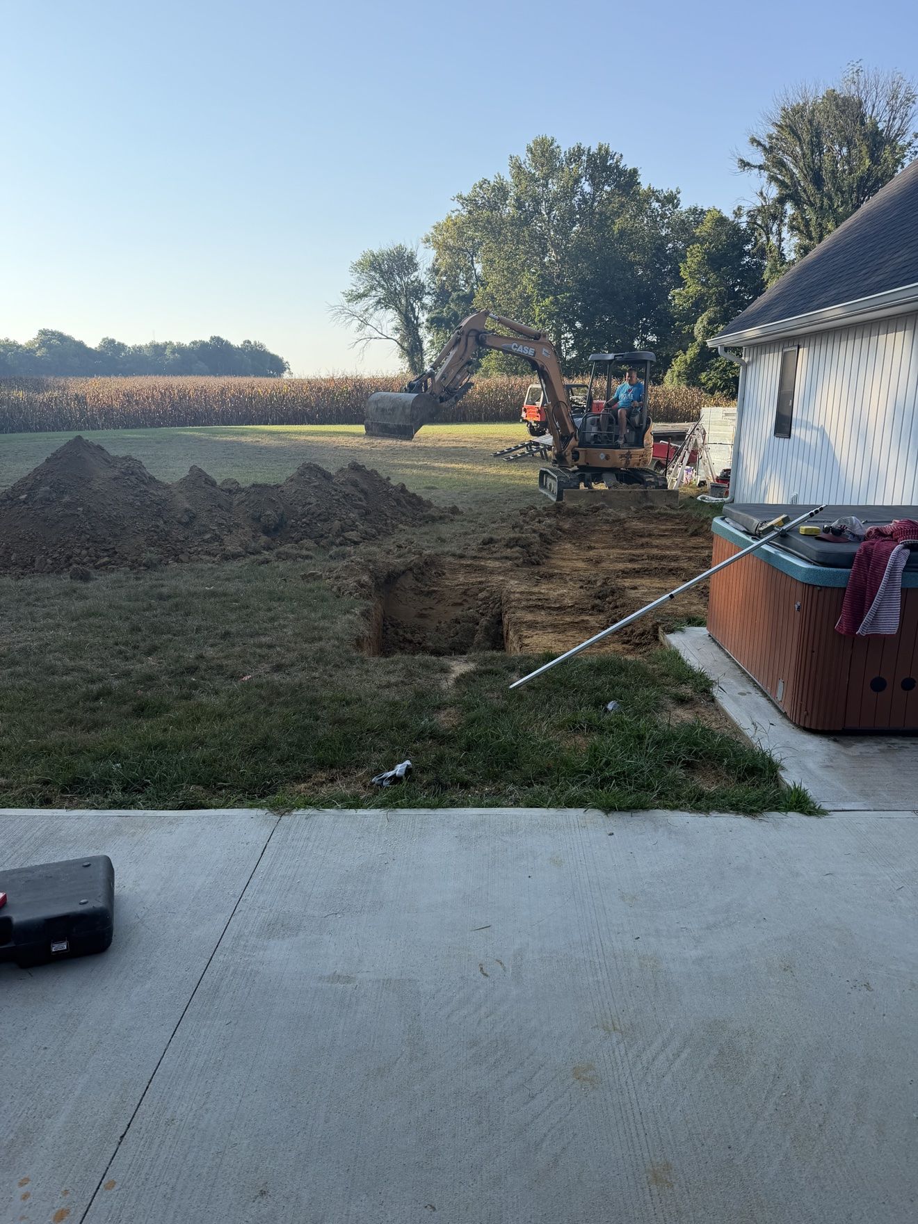 Mini excavator digging the hole for a steel-wall inground pool build